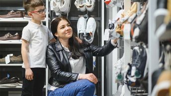 Mãe e filho escolhendo tênis em uma loja no shopping