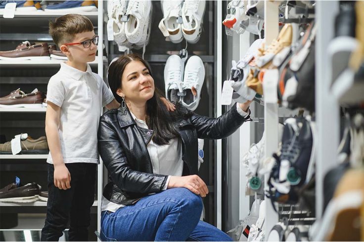 Mãe e filho escolhendo tênis em uma loja no shopping