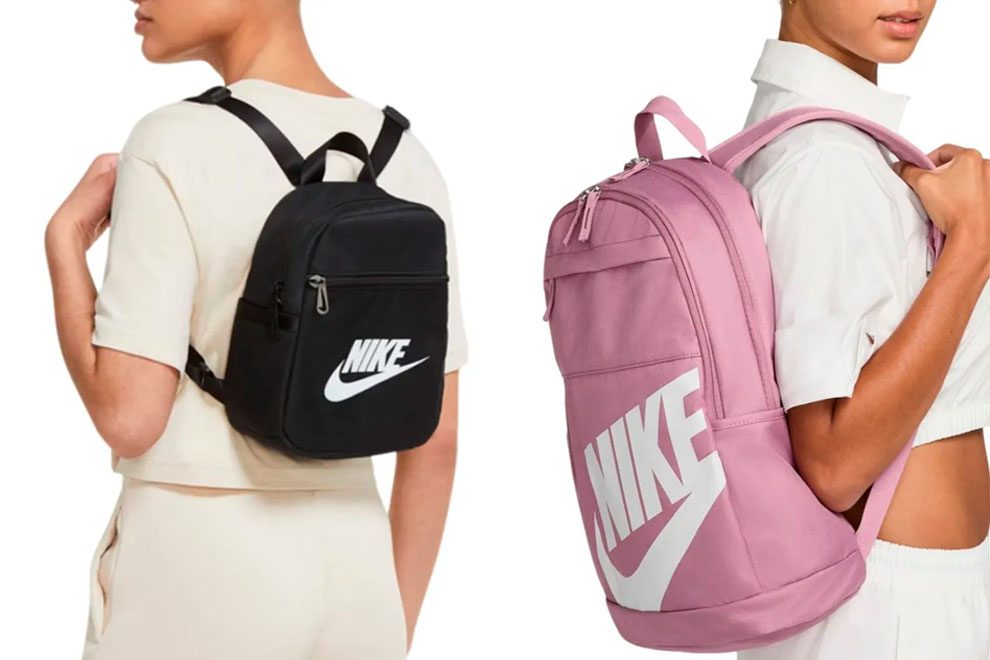 modelos femininas usando uma mochila pequena preta e uma mochila maior rosa claro da marca Nike em um fundo branco