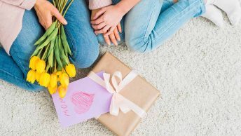 Mãe e filha com flores e presente no chão