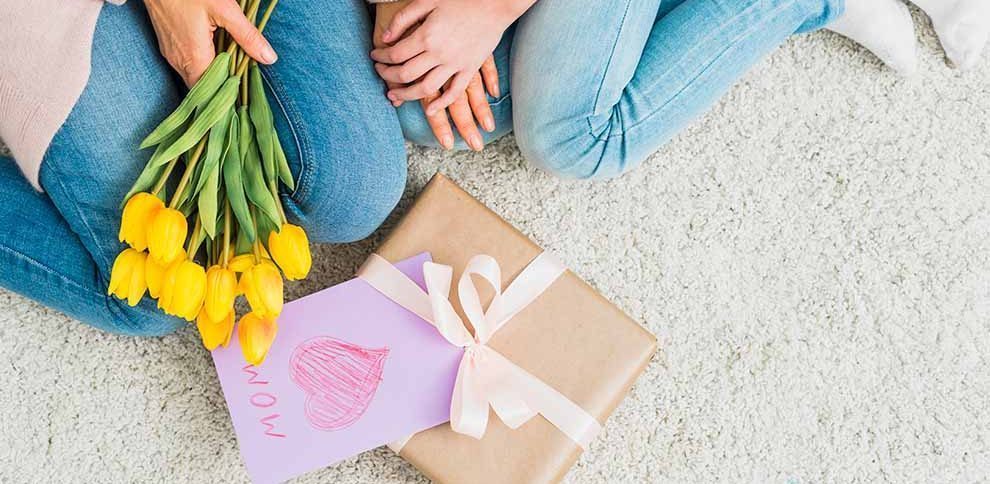 Mãe e filha com flores e presente no chão