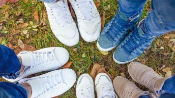 Várias pessoas com diferentes tênis em um ambiente natural.