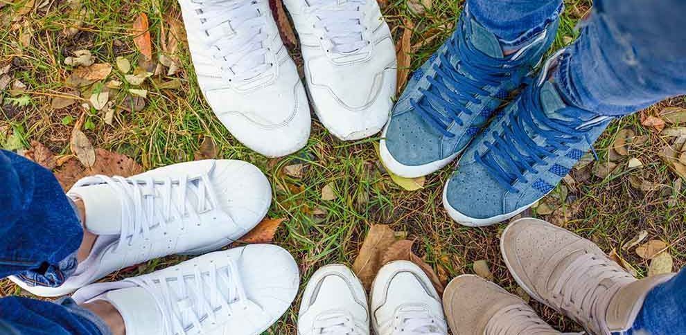 Várias pessoas com diferentes tênis em um ambiente natural.
