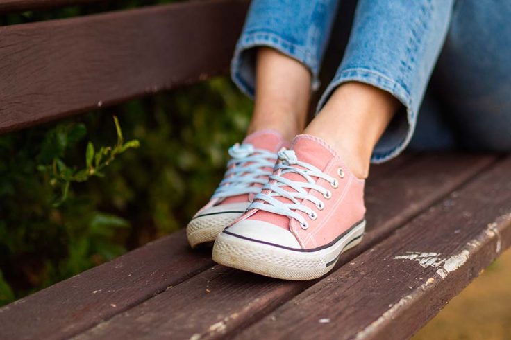 Tênis rosa sobre banco de madeira
