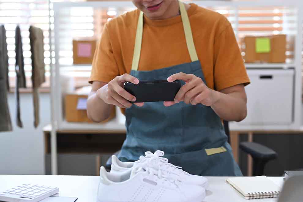 Pessoa fotografando tênis brancos em loja