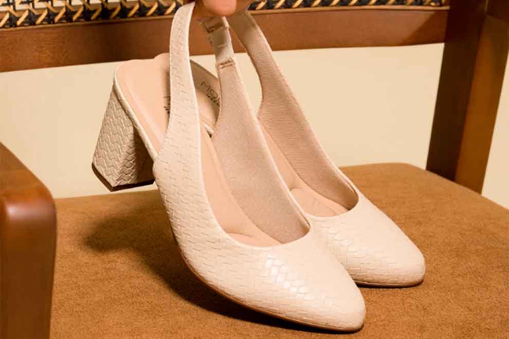 Sapatos de salto alto brancos em superfície marrom