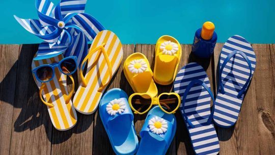 Chinels coloridos e óculos de sol à beira da piscina