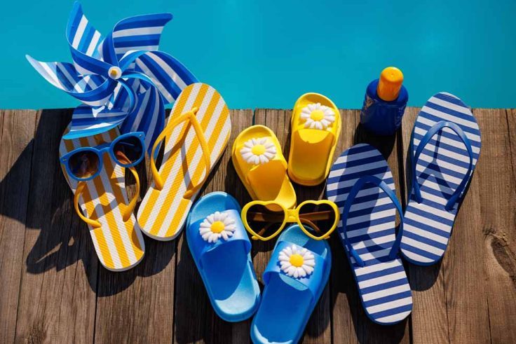 Chinels coloridos e óculos de sol à beira da piscina