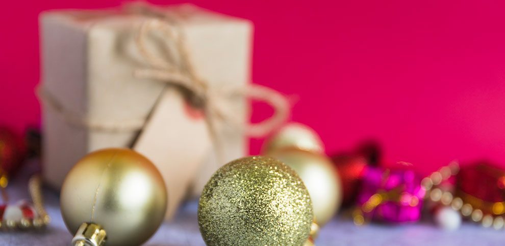 Decoração natalina com bolas douradas e presente.