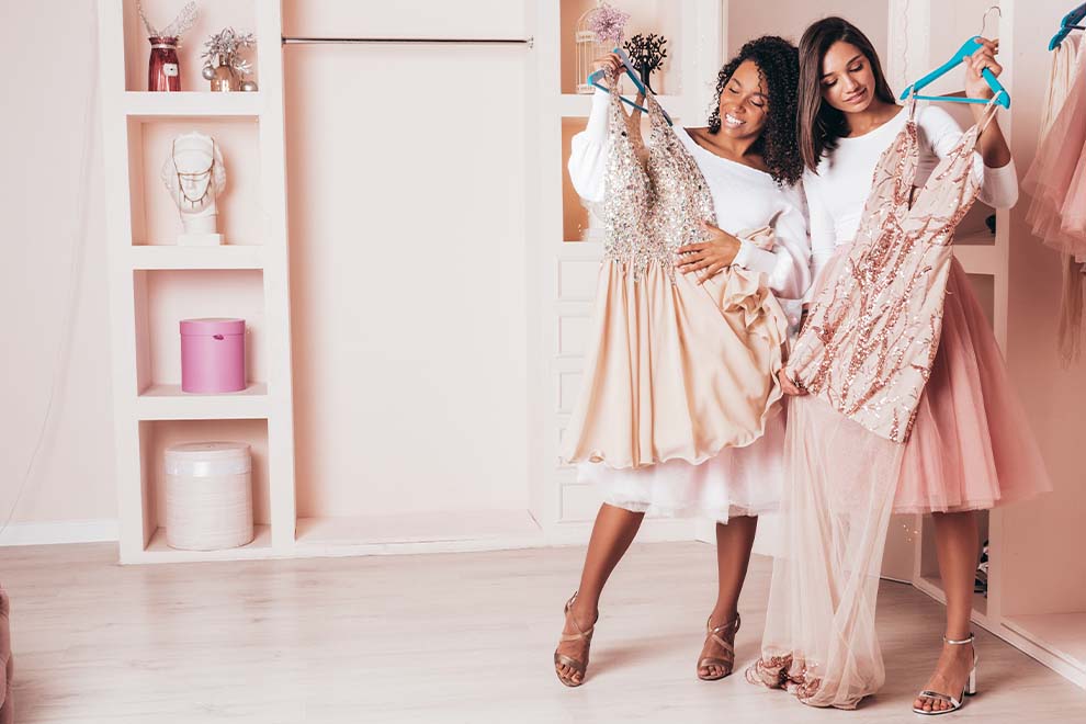 rosa quartzo Duas mulheres felizes experimentando vestidos em loja