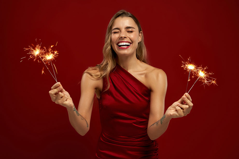 vermelho Mulher sorrindo com fogos de artifício em mãos