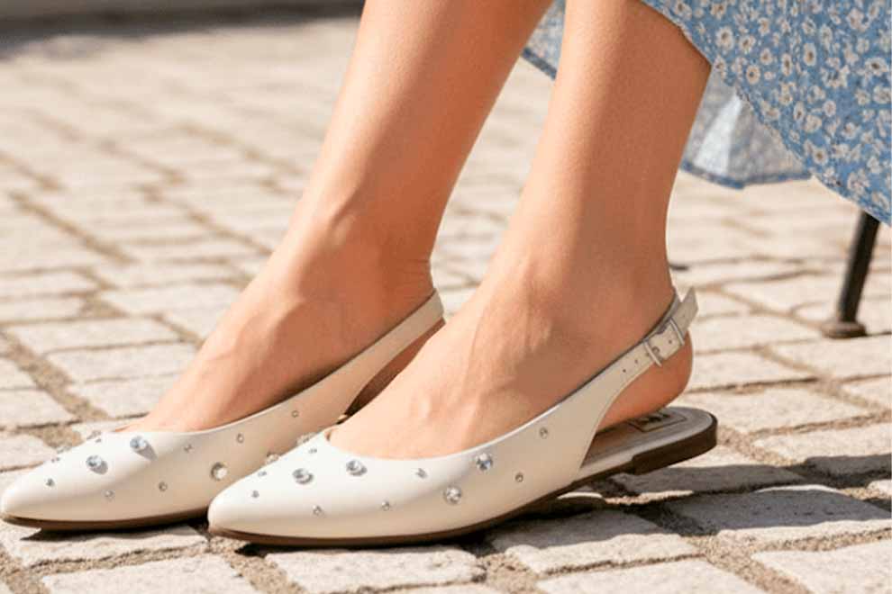 Sandalias brancas com strass em calçada de pedras