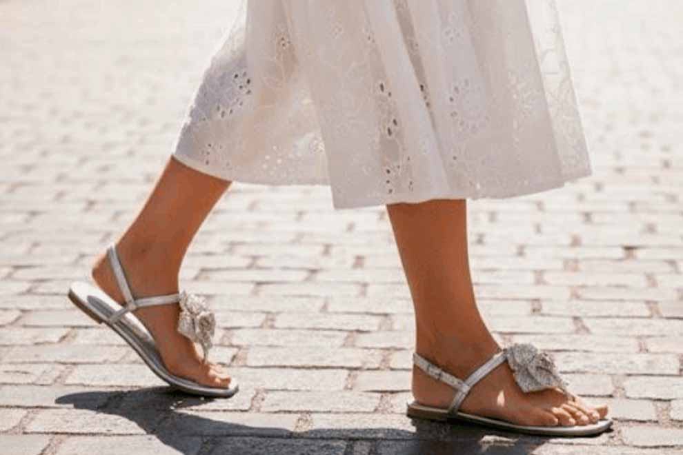 Sandálias prateadas com detalhes, caminhando em calçada