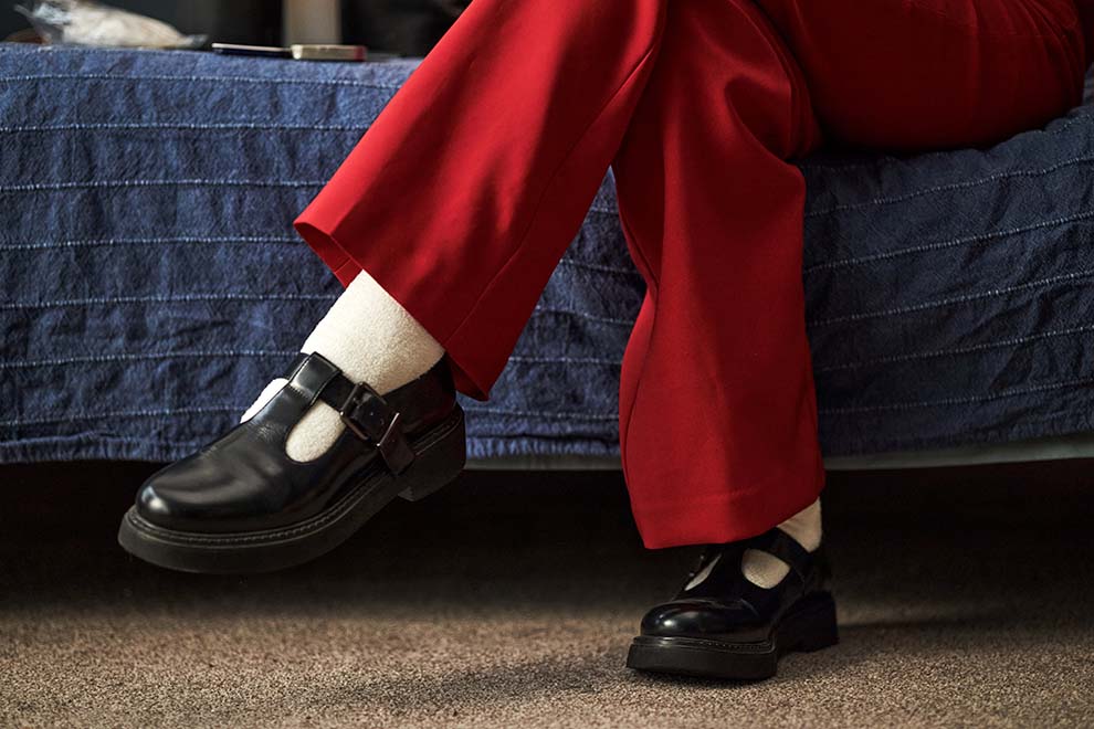 Pés com sapatos pretos e calças vermelhas