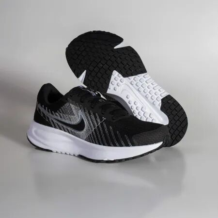 Tênis de corrida Nike preto e branco sobre fundo neutro
