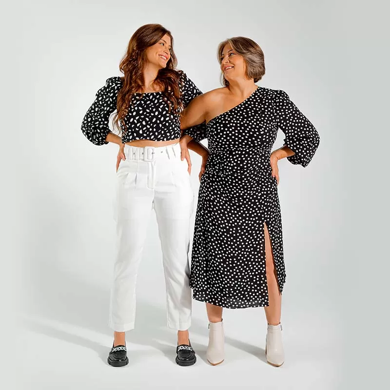 Duas mulheres em pé usando look parecido