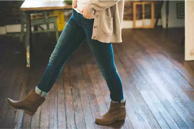 mulher usando suéter com bota de marrom