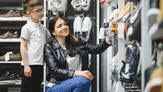 Mãe e filho escolhendo tênis em uma loja no shopping