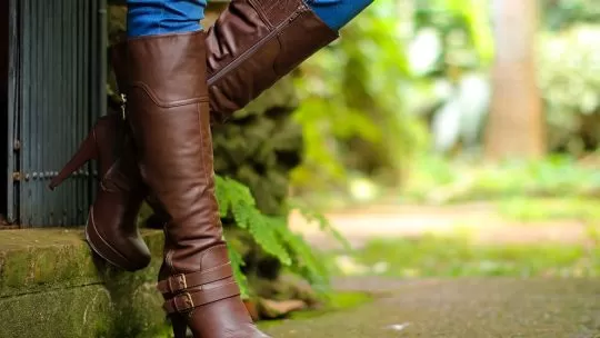 Bota marrom de couro com salto alto em ambiente natural
