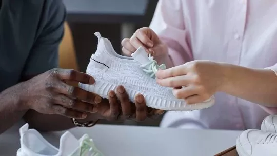 Pessoas experimentando tênis brancos novos