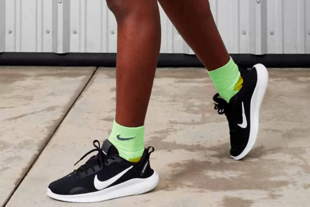 Tênis Nike pretos com meias verdes vibrantes.