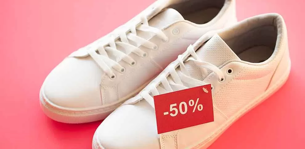 Tênis brancos com etiqueta de 50% de desconto