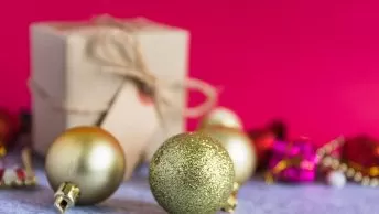 Decoração natalina com bolas douradas e presente.