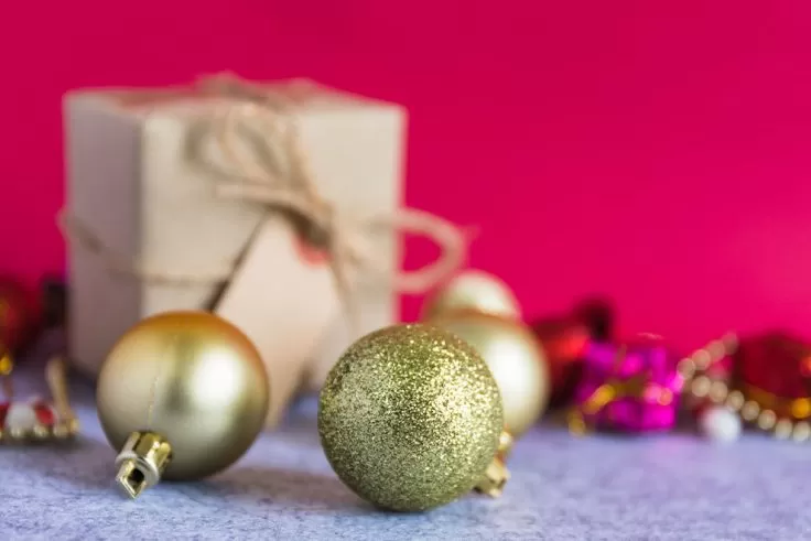 Decoração natalina com bolas douradas e presente.