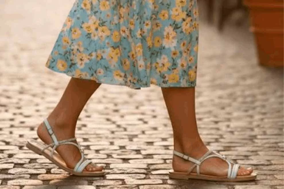 Mulher usando sandálias sob vestido floral
