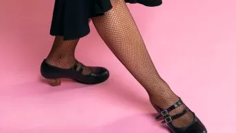 Pé feminino com meia-calça e sapato preto de salto