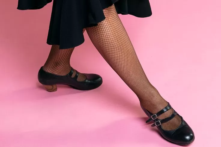 Pé feminino com meia-calça e sapato preto de salto