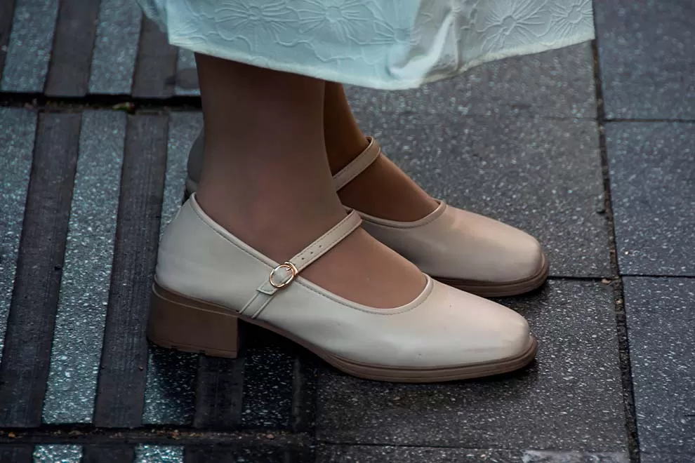 Sapatos elegantes de salto baixo em piso de pedras